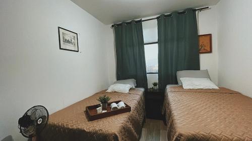 危地马拉Apartamento en centro Ciudad de Guatemala z12的一间卧室设有两张床和窗户。