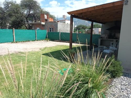 卡法亚特La Justina - Alquiler Temporario的后院设有绿色的围栏和草地