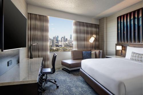 达拉斯达拉斯万丽酒店的配有一张床、一张书桌和一扇窗户的酒店客房