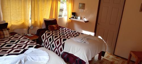 圣赫拉多德多塔Miriam'S Quetzals lodge的两张睡床彼此相邻,位于一个房间里