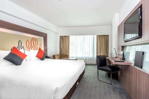 曼谷Hilton Garden Inn Bangkok Silom的一间酒店客房,配有一张大床和一台平面电视