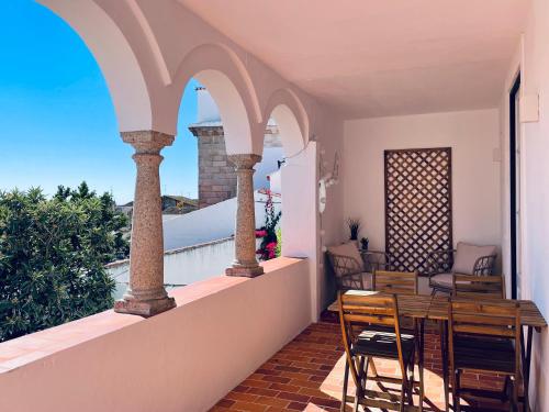 埃武拉Casa Soure Suites and Apartments的设有一个配有桌椅并享有美景的阳台。