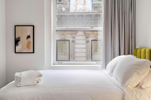 蒙特利尔The Nomad Saint Jacques的卧室配有白色的床和窗户。