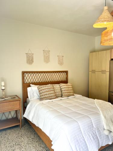圣胡安Villa Bamboo的卧室配有一张白色的大床和一张桌子