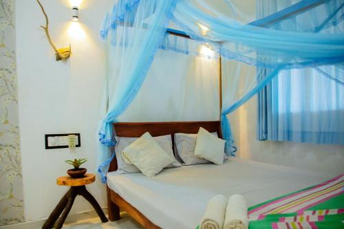 蒂瑟默哈拉默New Cormorant Lake Resort & Yala Safari Place的一间卧室配有一张蓝色窗帘的床