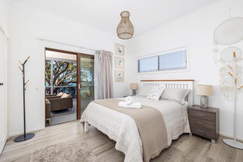 尼尔森湾Dutchie's View - Direct access to the beach的白色的卧室设有床和窗户
