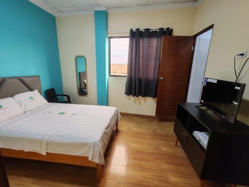 YurimaguasHOTEL EL TREBOL的一间卧室配有一张床和一台平面电视