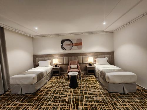 Ash Sharāʼi‘فندق كنف - kanaf hotel的酒店客房,配有两张床和椅子