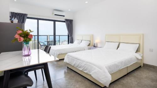 西哈努克AIR APARTMENTS Residence - Sihanoukville - 400m to boat pier的酒店客房,设有两张床和一张鲜花桌。