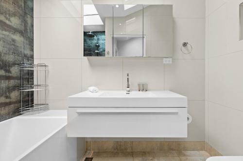 悉尼Elegant 1-Bed with Study by Balmain Wharf的白色的浴室设有水槽和浴缸。