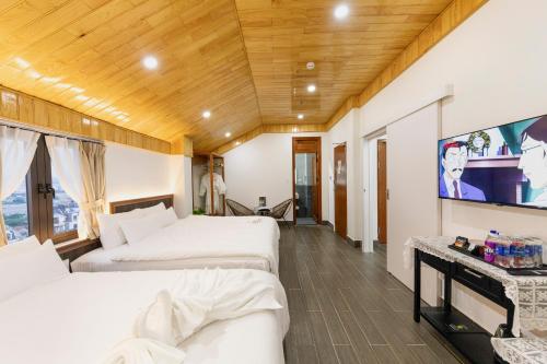 胡志良Olagi Hotel 2的客房设有两张床和一台平面电视。