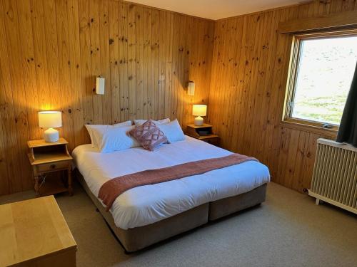佩里舍峡谷Peer Gynt Ski Lodge的一间卧室配有一张带木墙和窗户的床。