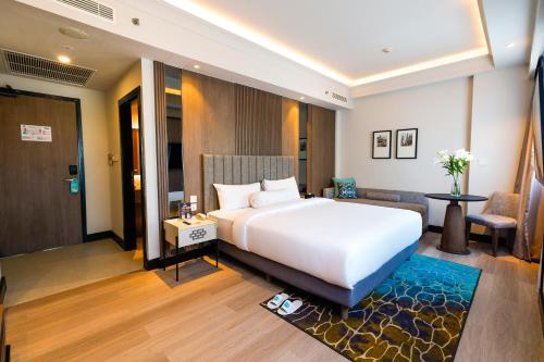 泗水Deka Hotel Surabaya HR Muhammad的一间带白色床的卧室和一间客厅