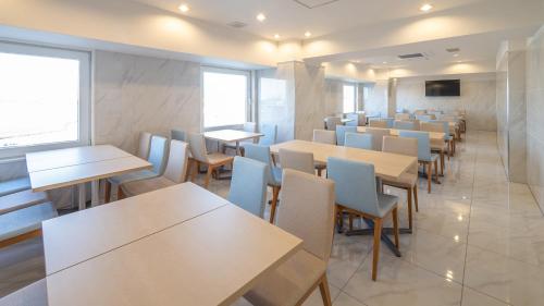 北九州Toyoko Inn Kokura-eki Kita-guchi的用餐室设有桌椅和窗户。