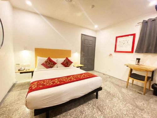 新德里Hotel Diamond Tree at Pitampura的一间卧室配有一张大床和一张书桌