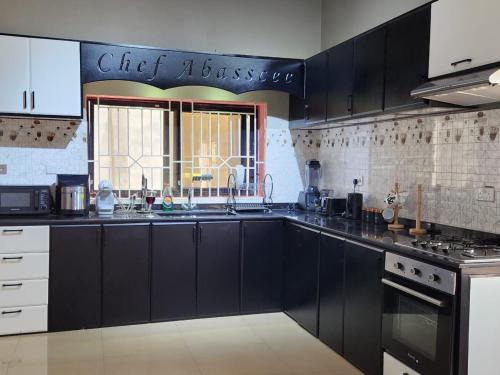 弗里敦Prestigious Elegant Duplex - Abasscee的一间设有黑色橱柜和窗户的大厨房