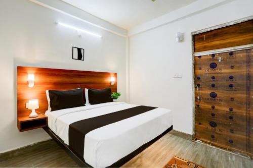 坎普尔OYO Flagship HOTEL MADHUBAN'S INN的一间卧室配有一张大床和木制床头板