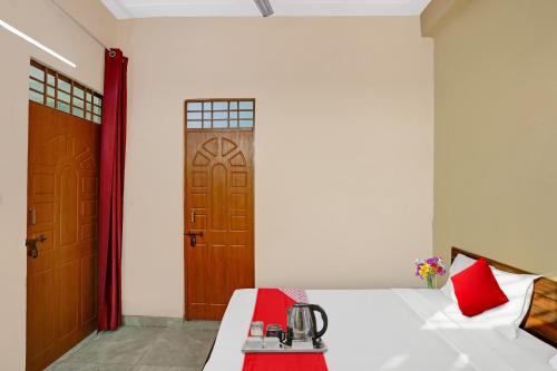 加济阿巴德Flagship Sweet Homes的一间卧室配有一张带红色枕头的床和一扇门