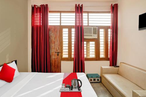 加济阿巴德Flagship Sweet Homes的一间卧室配有床、沙发和红色窗帘