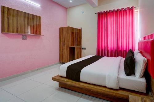 哈尔德瓦尼OYO HOTEL STAY INN的卧室配有一张带粉红色墙壁的大床