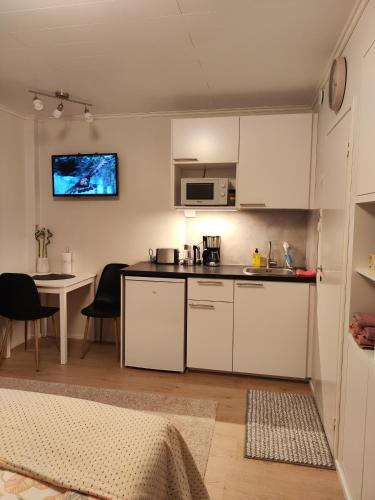 瓦尔考斯Kauppakatu 57 - 8的厨房配有白色橱柜和桌椅