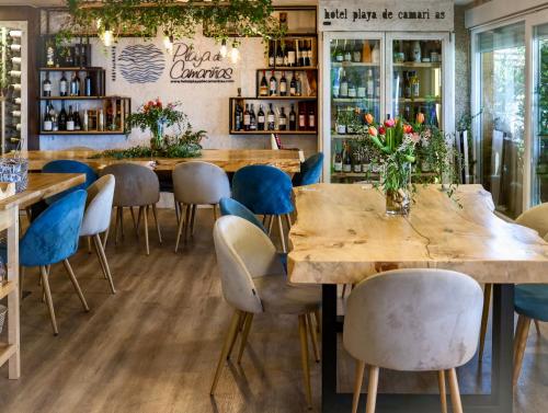 卡马里尼亚斯Playa de Camariñas的餐厅设有木桌和蓝色椅子