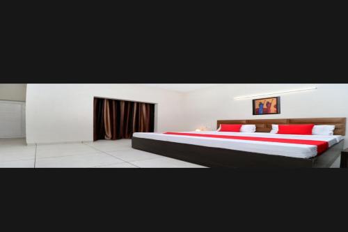 NārnaulOYO Vihan Palace的一间卧室配有一张带红色枕头的大床