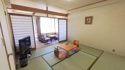 伊喜末HOTEL GREEN PLAZA SHODOSHIMA - Vacation STAY 71488v的客厅配有桌子和电视