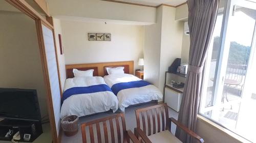 伊喜末HOTEL GREEN PLAZA SHODOSHIMA - Vacation STAY 71488v的一间卧室配有蓝色和白色床单