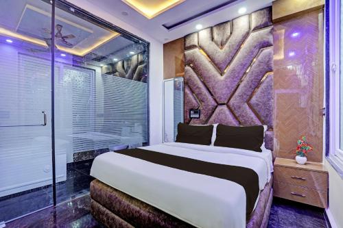 新德里OYO HOTEL MOUNT PALACE的一间卧室设有一张大床和一个窗户。