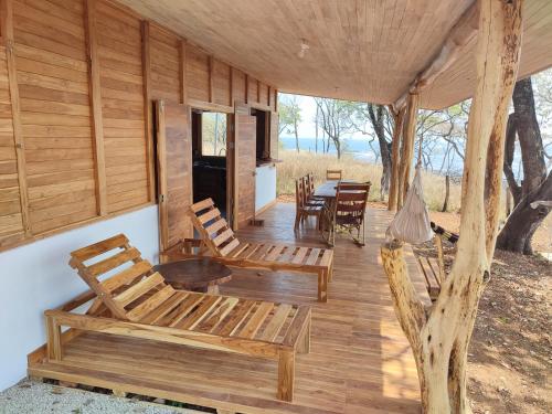 VenadoCasa Lagarto Beachfront的小木屋的门廊配有桌椅
