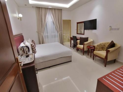 尼兹瓦尼兹瓦酒店公寓的配有一张床和一把椅子的酒店客房