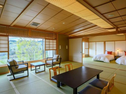 SagaeHotel Symphony Annex Sagae Onsen的配有一张床和一张桌子及椅子的房间