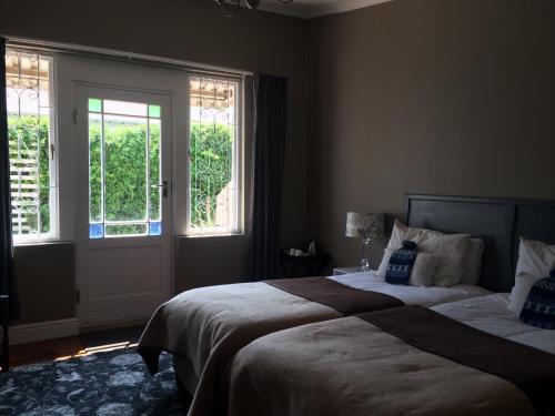 格拉罕镇30 on Oatlands Road的一间卧室设有两张床和两个窗户。
