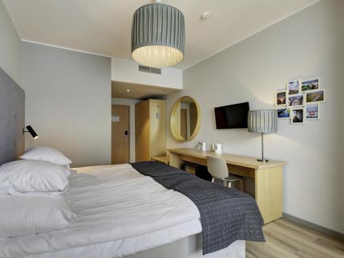 派尔努爱沙尼亚度假酒店及Spa的一间卧室配有一张床、一张书桌和一台电视