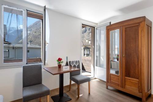 CavergnoCasa Al Torchio 1,2,3 and 4 - Happy Rentals的客房设有桌椅和窗户。