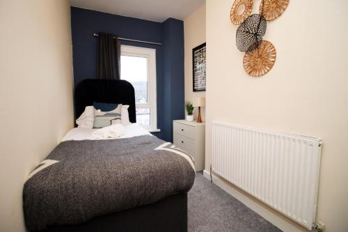 AbertilleryCosy 3BR Home, Scenic Views, Ideal for Walks & Work的一间卧室设有一张床和一个窗口