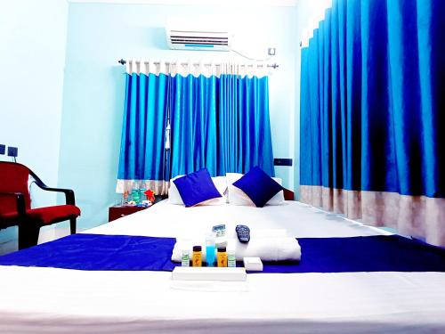 杜尔加布尔The Amber的一间卧室配有一张带蓝色窗帘的大床