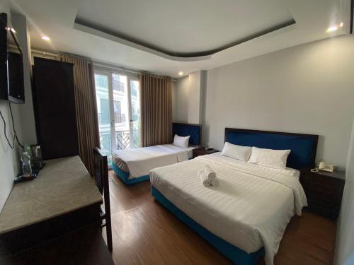 河内Mimi Housing的酒店客房设有两张床和电视。