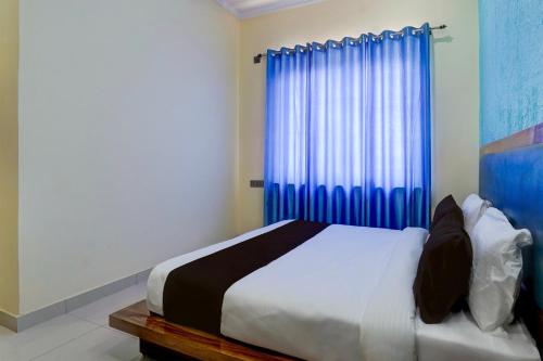 哈尔德瓦尼OYO HOTEL STAY INN的一间卧室配有一张蓝色窗帘的床