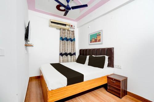 兰纳加OYO Premier Jim Corbett Home Stay的一间卧室配有一张床和吊扇