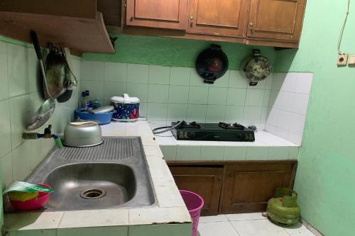日惹OYO 93839 Aquenda Homestay的厨房配有水槽和炉灶