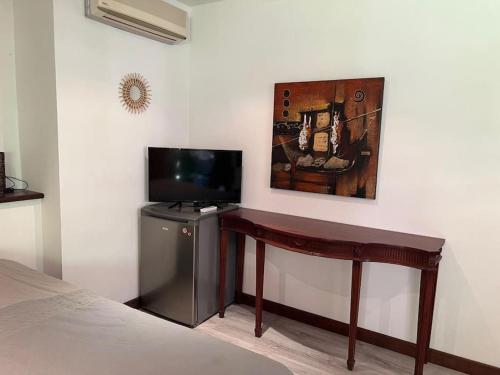 SarraméaBungalow Sarraméa的客房设有一张桌子,墙上配有电视