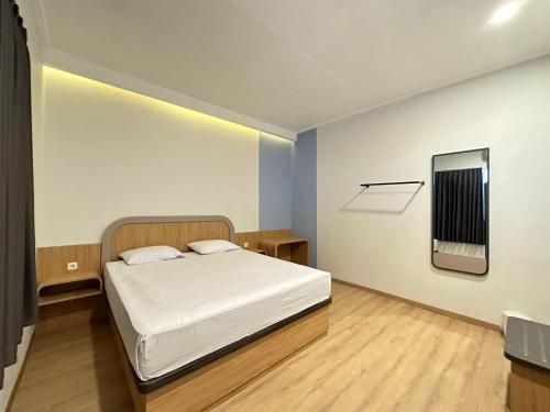 三宝垄Hotel Plampitan的一间小卧室,配有一张床和镜子