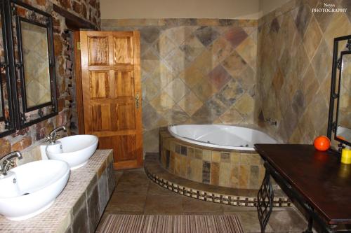 KareedouwSoloko Game farm的浴室配有两个盥洗盆和浴缸。