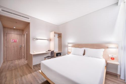 奥埃拉斯Moov Hotel Oeiras的卧室配有一张白色大床和一张书桌