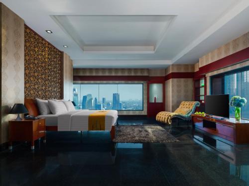 雅加达曼哈顿雅加达酒店的一间卧室配有一张床、一张书桌和一台电视