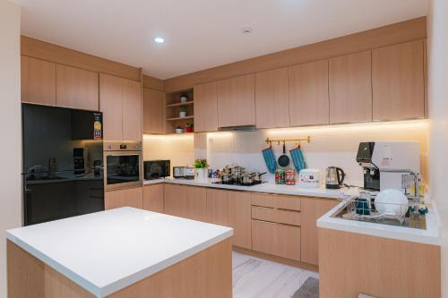 曼谷MODERN - 6Beds, CITY CENTER, Phrom Phong BTS, Emquartier, Terminal 21的一个带木制橱柜和白色台面的大厨房