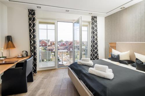 朗格奥洛格胡斯朗格奥格酒店的一间卧室配有一张带书桌的床和一个阳台