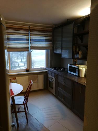 马热伊基艾Apartamentai 78的一间带桌子和微波炉的小厨房
